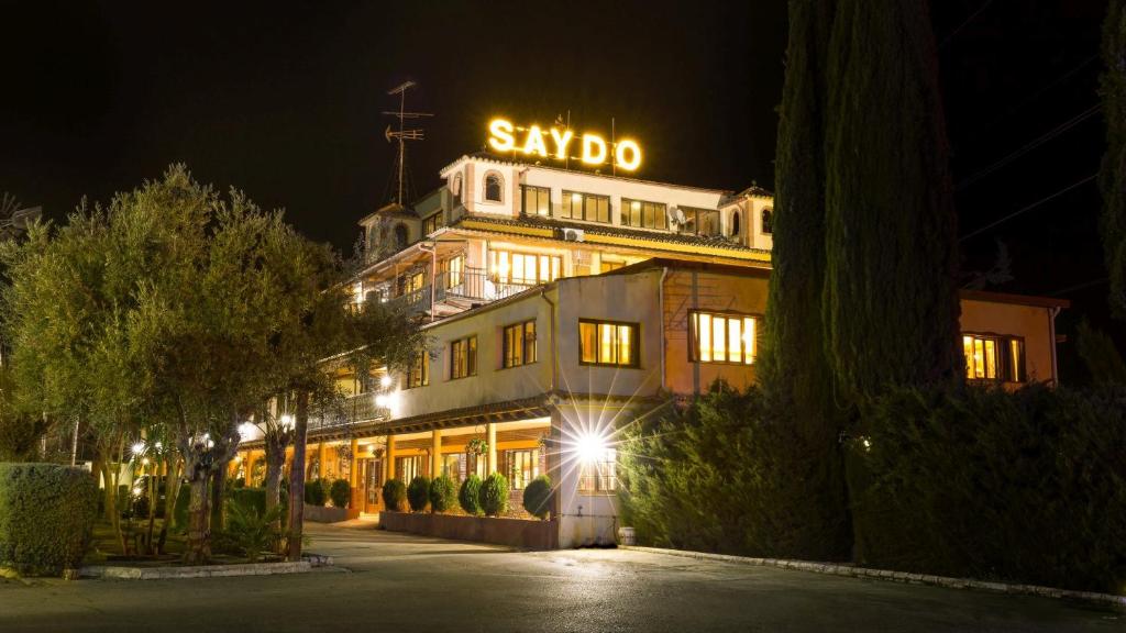 a building with a sign on top of it at night at Hotel Molino De Saydo in Mollina