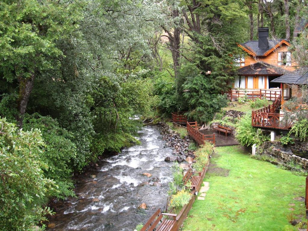 a stream in front of a house next to a river at Cabañas Temporada in San Martín de los Andes