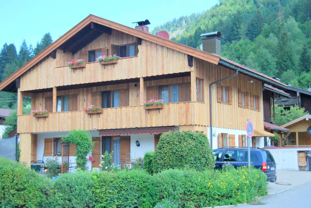 a large wooden building with flowers on the windows at Haus-Brecherspitzblick in Schliersee