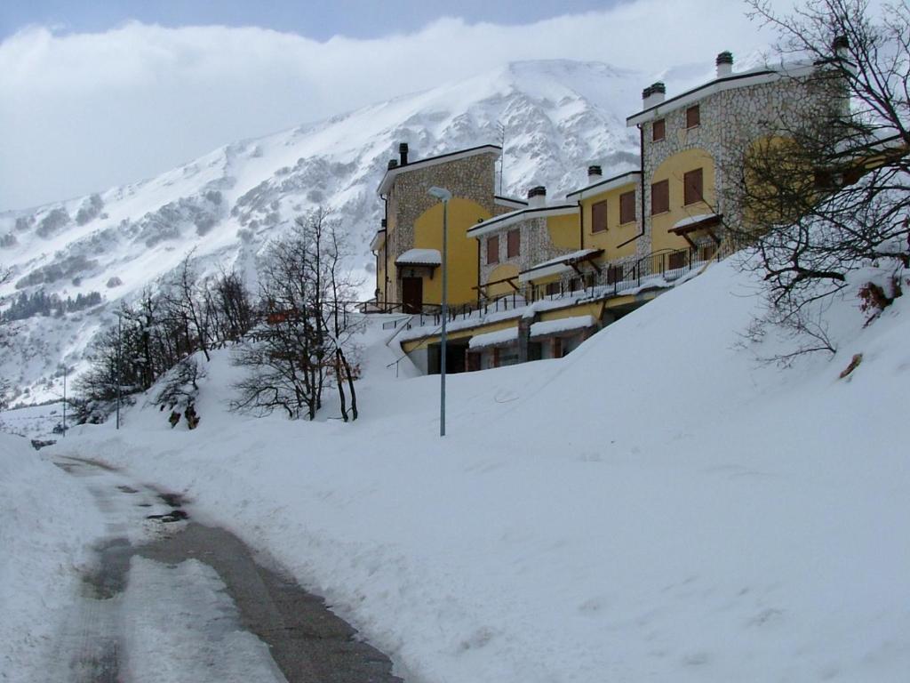 budynek w śniegu obok góry w obiekcie Appartamento i Cerri w mieście Rocca di Cambio