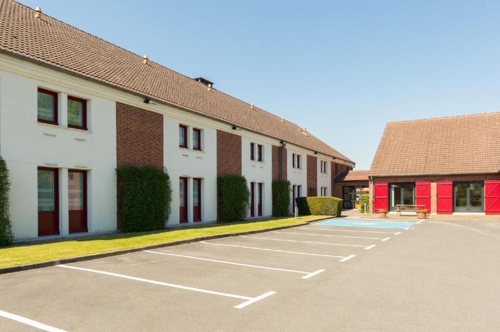 un parking vide devant un bâtiment dans l'établissement The Originals City, Hôtel Le Gayant, Douai (Inter-Hotel), à Douai