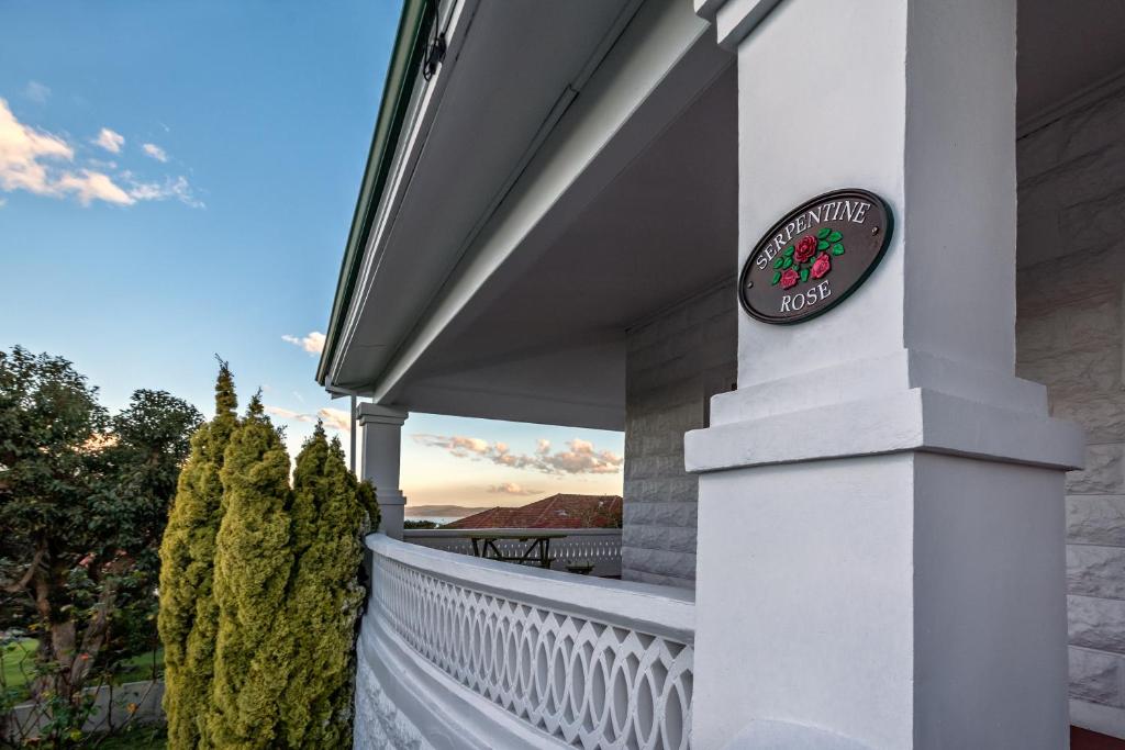 a house with a sign on the side of a porch at Serpentine Rose in Albany