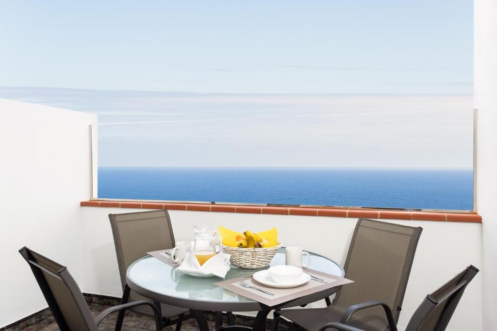 a table and chairs with a view of the ocean at El Rincón with Sea View II in Icod de los Vinos