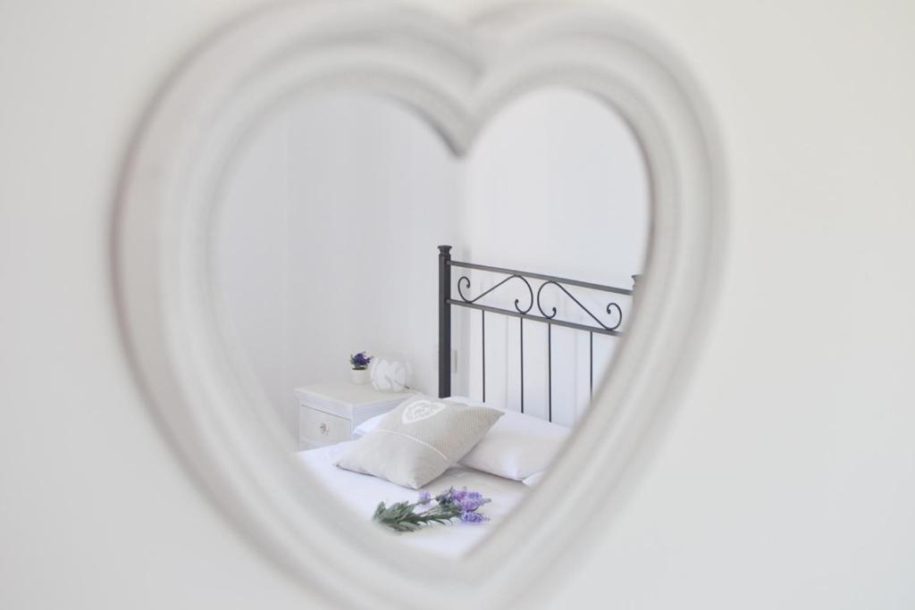 1 dormitorio con 1 cama con espejo en forma de corazón en Casa Chiara Verona, en Verona