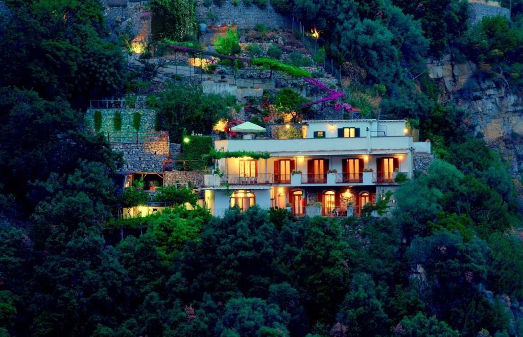 een huis aan de zijkant van een berg 's nachts bij Villa Punta del Sole in Positano