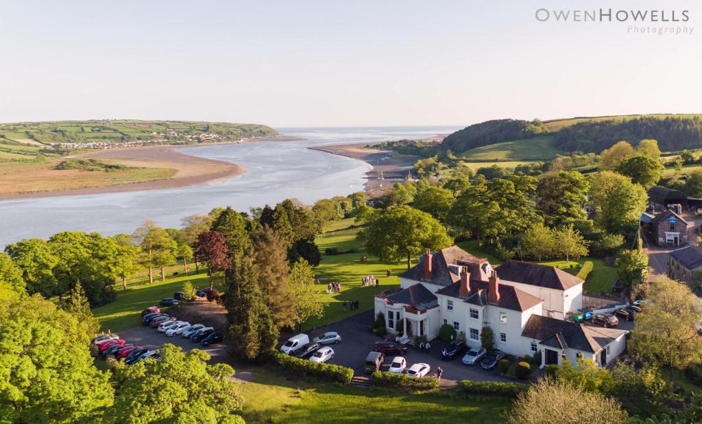 an aerial view of a house next to a river at Mansion House Llansteffan in Carmarthen