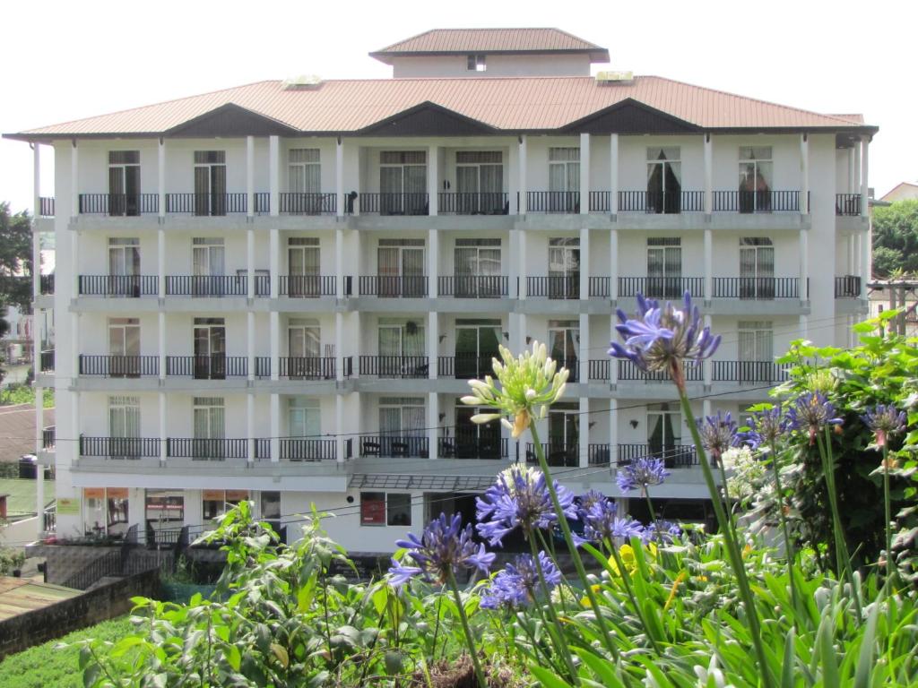 un edificio con dei fiori davanti di Shinic Holiday Inn a Nuwara Eliya