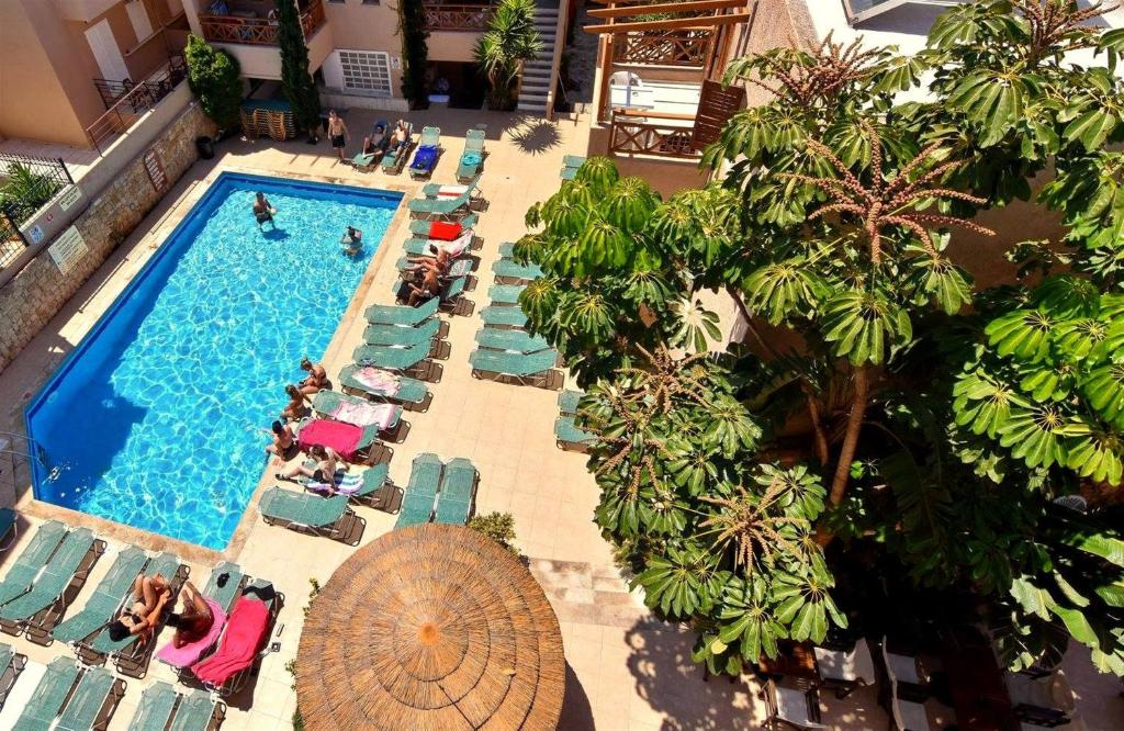 an overhead view of a swimming pool with chairs and people at 24 Seven Boutique Hotel in Malia
