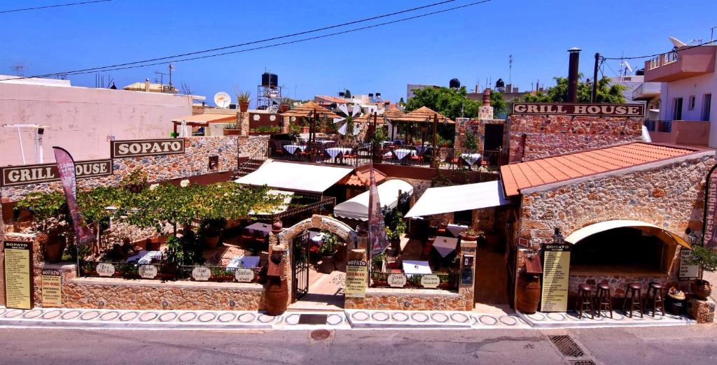 a building with a restaurant in the middle of a street at 24 Seven Boutique Hotel in Malia