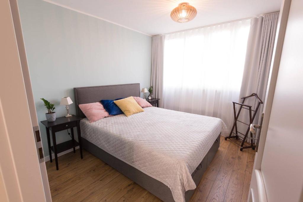 1 dormitorio con 1 cama con almohadas rosas y azules en Studzienna, en Wroclaw