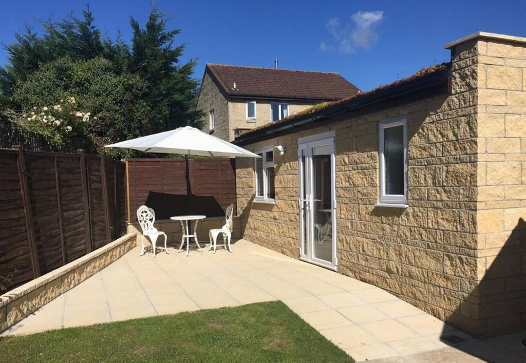 a patio with an umbrella and a table and chairs at Beautiful Modern Apartment in Bath in Bath