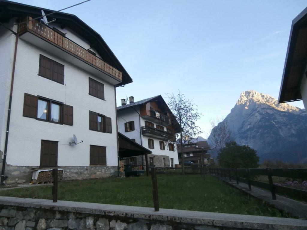a white building with a mountain in the background at Flora Quinz in Sappada