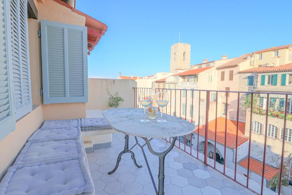 un patio avec une table et des chaises sur un balcon dans l'établissement CLT - UNIQUE Duplex & Terrace on the Provencal market, à Antibes
