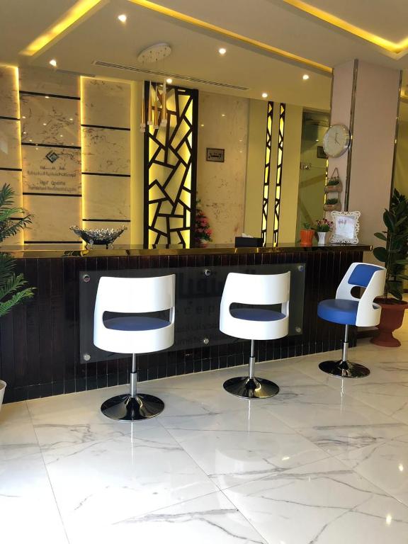 three chairs sitting in front of a counter in a salon at Hala Onaizah in Unayzah
