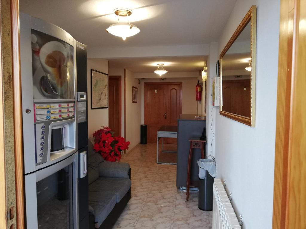 een woonkamer met een bank en een magnetron bij Hostal Residencia Taray in Segovia