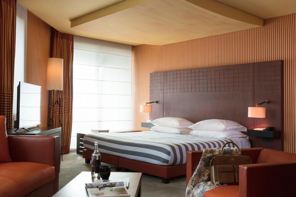 um quarto de hotel com uma cama e um sofá em Hotel Square em Paris