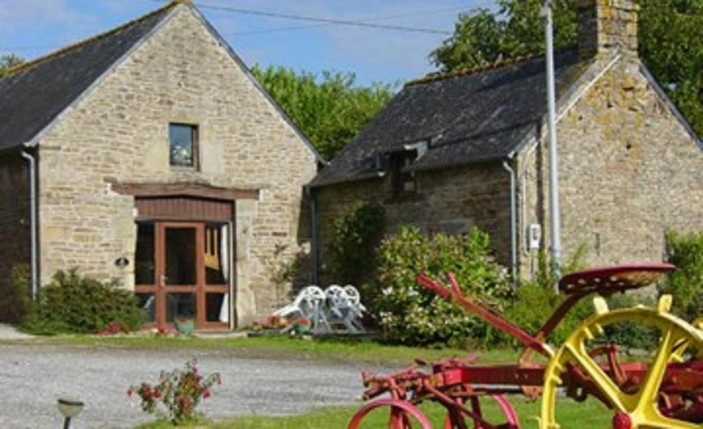 une maison en pierre avec un vélo rouge devant elle dans l'établissement Gîte du Roi Morvan, à Ploërdut