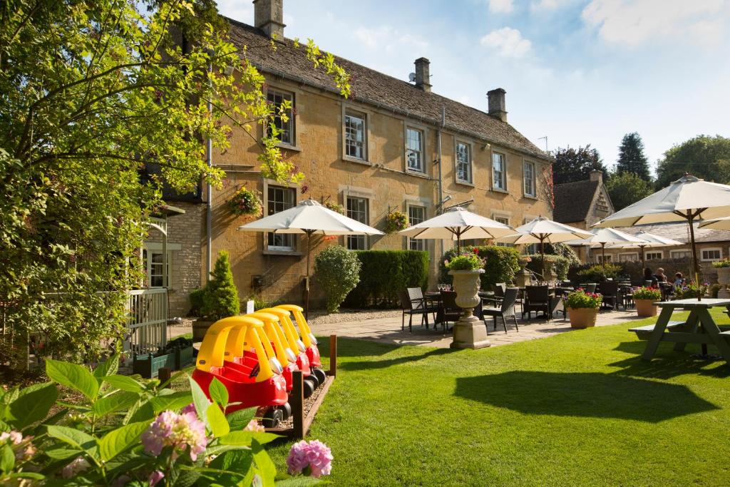 a hotel with a garden with a large building at The Inn at Fossebridge in Chedworth