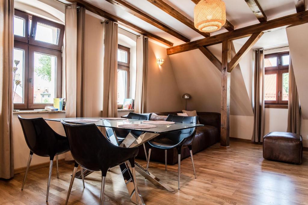 Drzewna Apartamenty-Drzewna في جلونا غورا: غرفة طعام مع طاولة وكراسي
