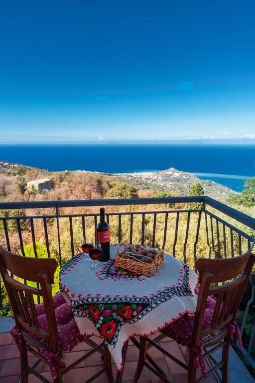 a table with a bottle of wine on a balcony at Cresta Panoramic apartments in Naso