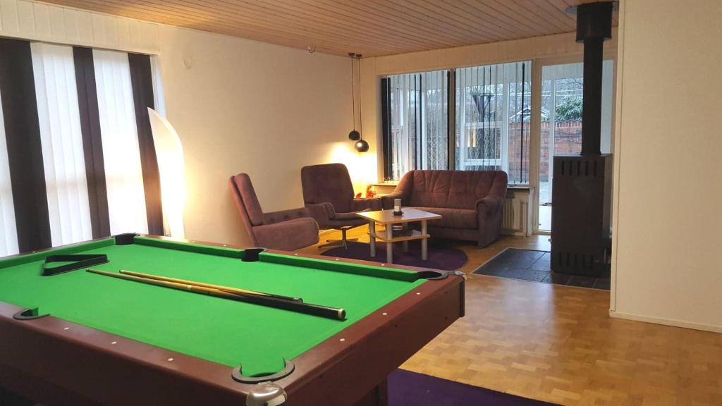 a living room with a pool table and chairs at Holstebro Townside House in Holstebro