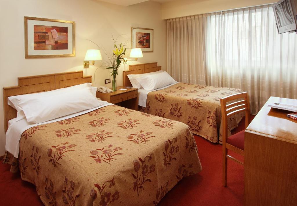 Cette chambre comprend deux lits et un bureau. dans l'établissement Wilton Hotel Buenos Aires, à Buenos Aires