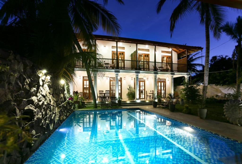 a house with a swimming pool in front of a building at Annavilla in Tangalle