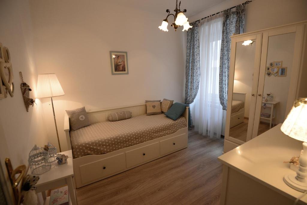 Dormitorio pequeño con cama y espejo en Casa Perugino en Trieste