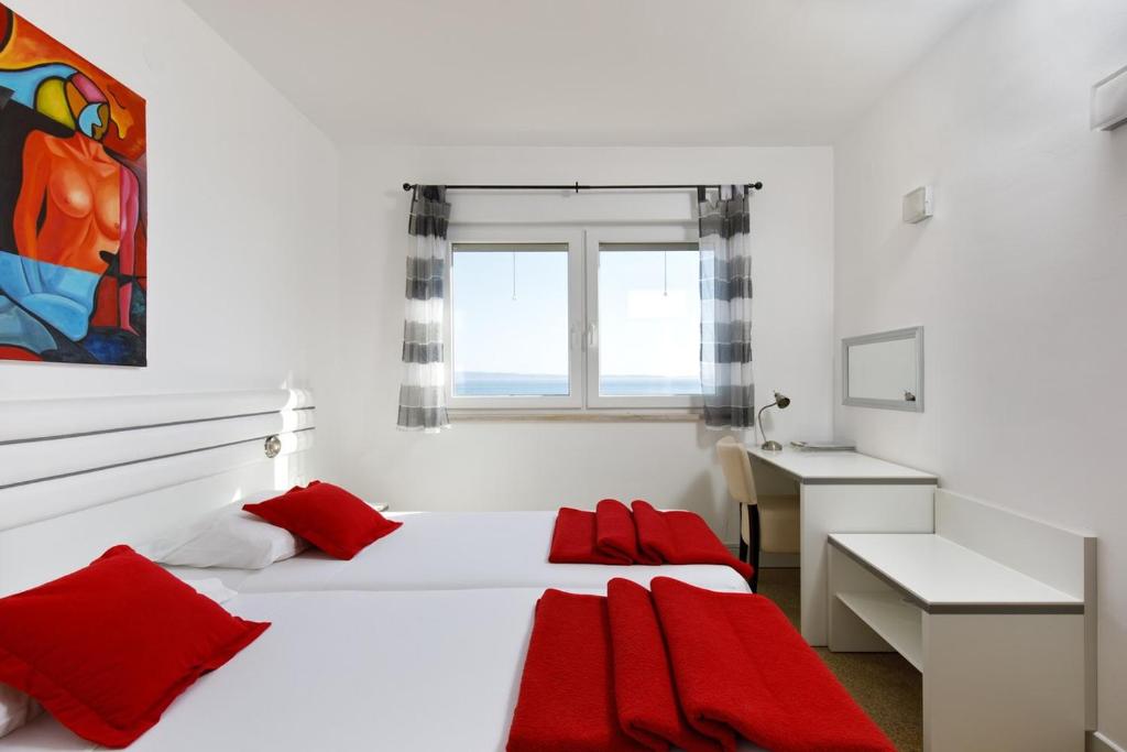 a white bedroom with two beds and a desk at Ark Beach Apartments in Split