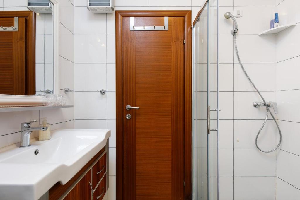a bathroom with a shower and a wooden door at Ark Beach Apartments in Split