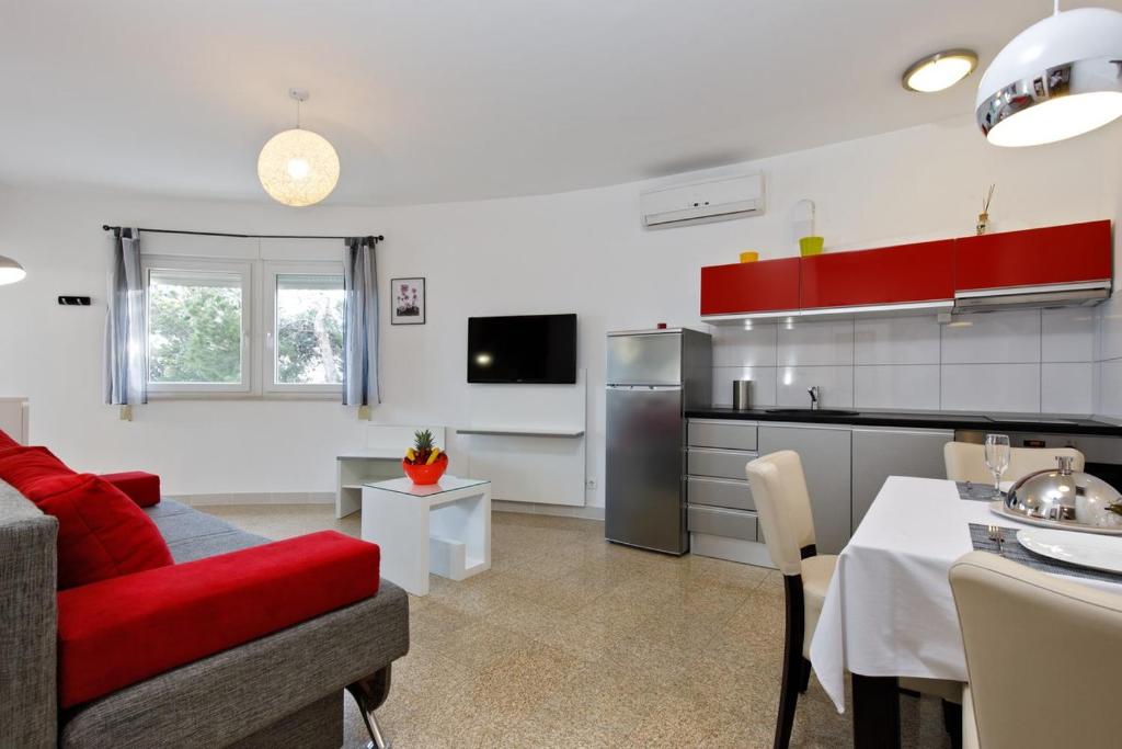 a kitchen and a living room with a red couch at Ark Beach Apartments in Split