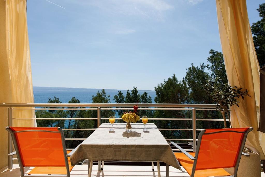 a table and chairs on a balcony with a view of the ocean at Ark Beach Apartments in Split