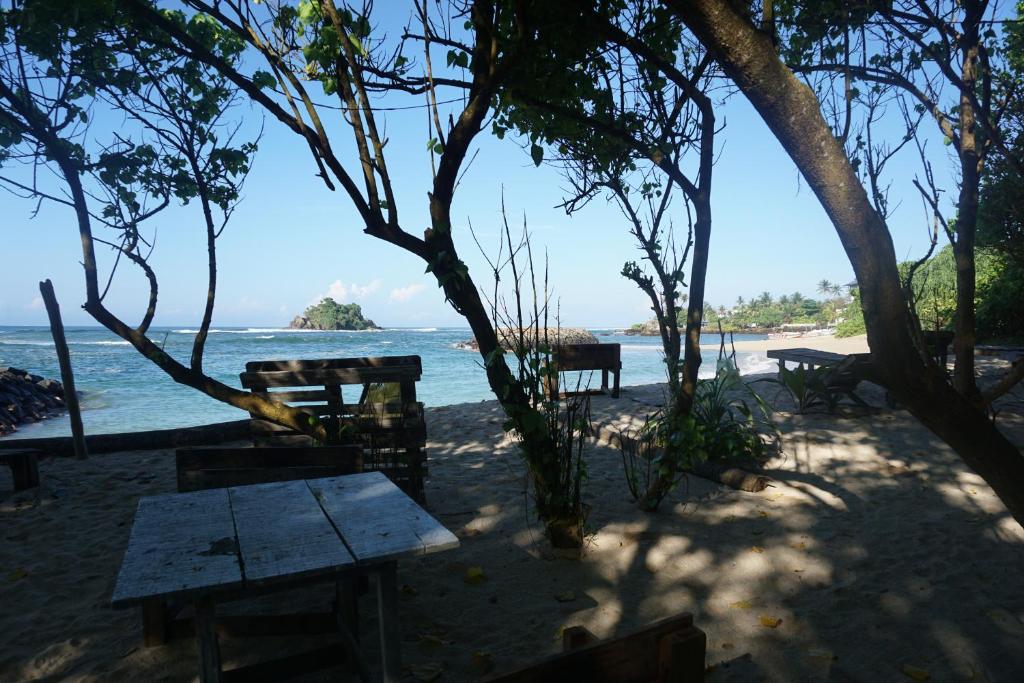a picnic table on the beach near the water at The Whitegates Lodge in Weligama