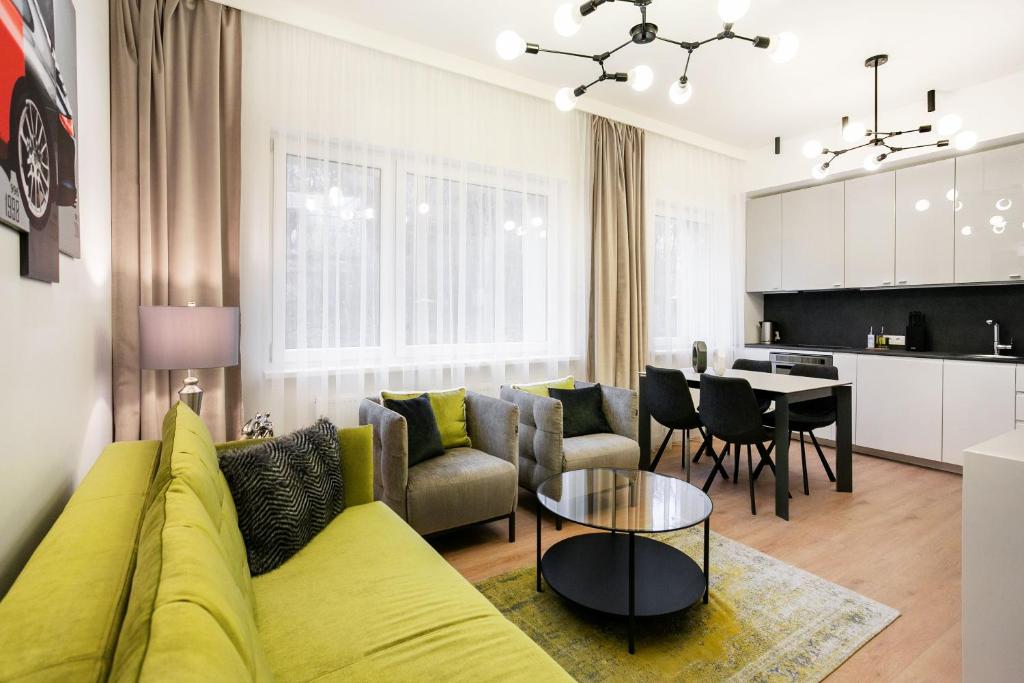 ein Wohnzimmer mit einem gelben Sofa und einem Tisch in der Unterkunft Luxury for everyone - Hills Park Lux Apartments 2 in Vilnius