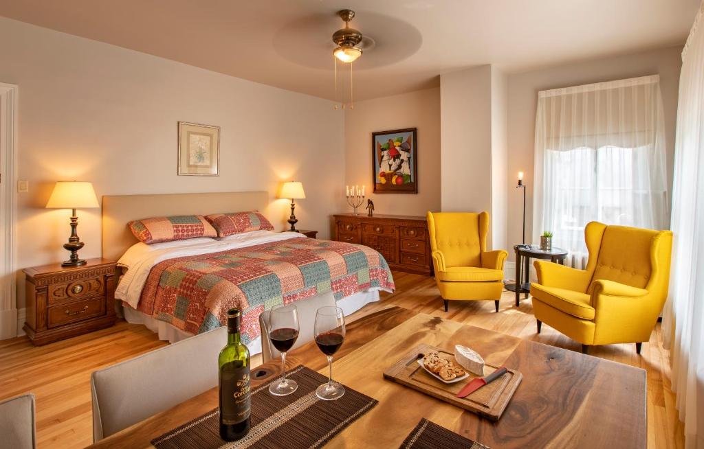 Un dormitorio con una cama y una mesa con copas de vino. en Gite du Quartier des Arts, en Quebec