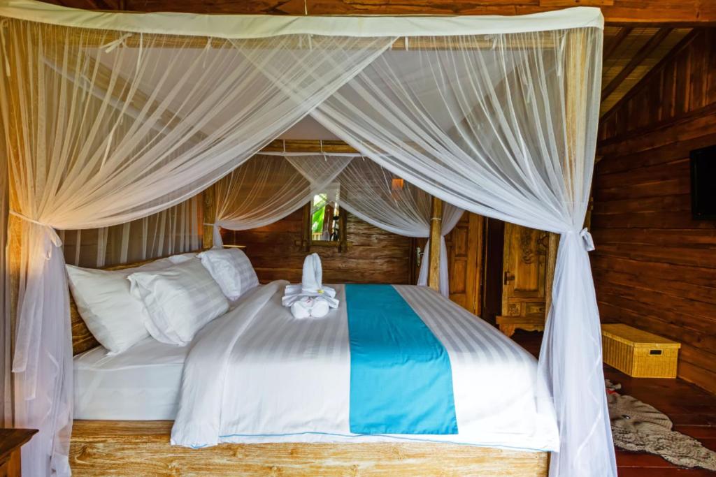 a bedroom with a bed with a canopy at Bali Natha Beach Front in Canggu