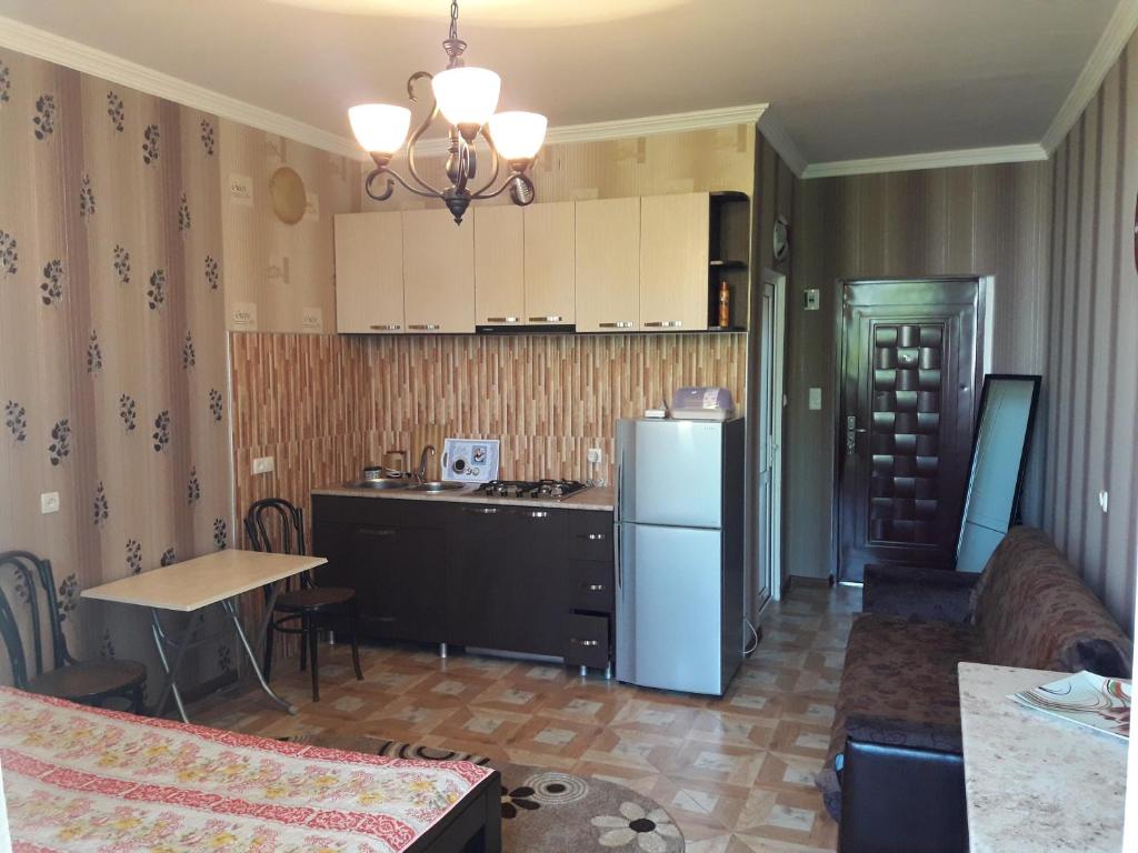 - une cuisine avec un réfrigérateur et une table dans la chambre dans l'établissement Kobuleti Rezidense, à Kobuleti