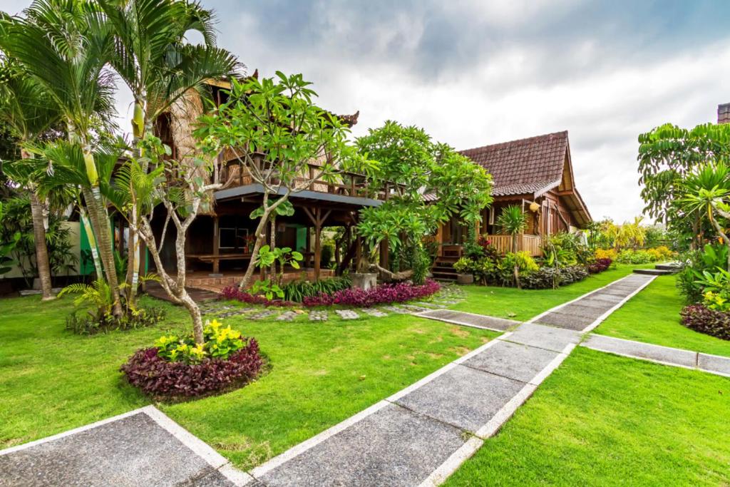 a house with a garden in front of it at Bali Natha Beach Front in Canggu