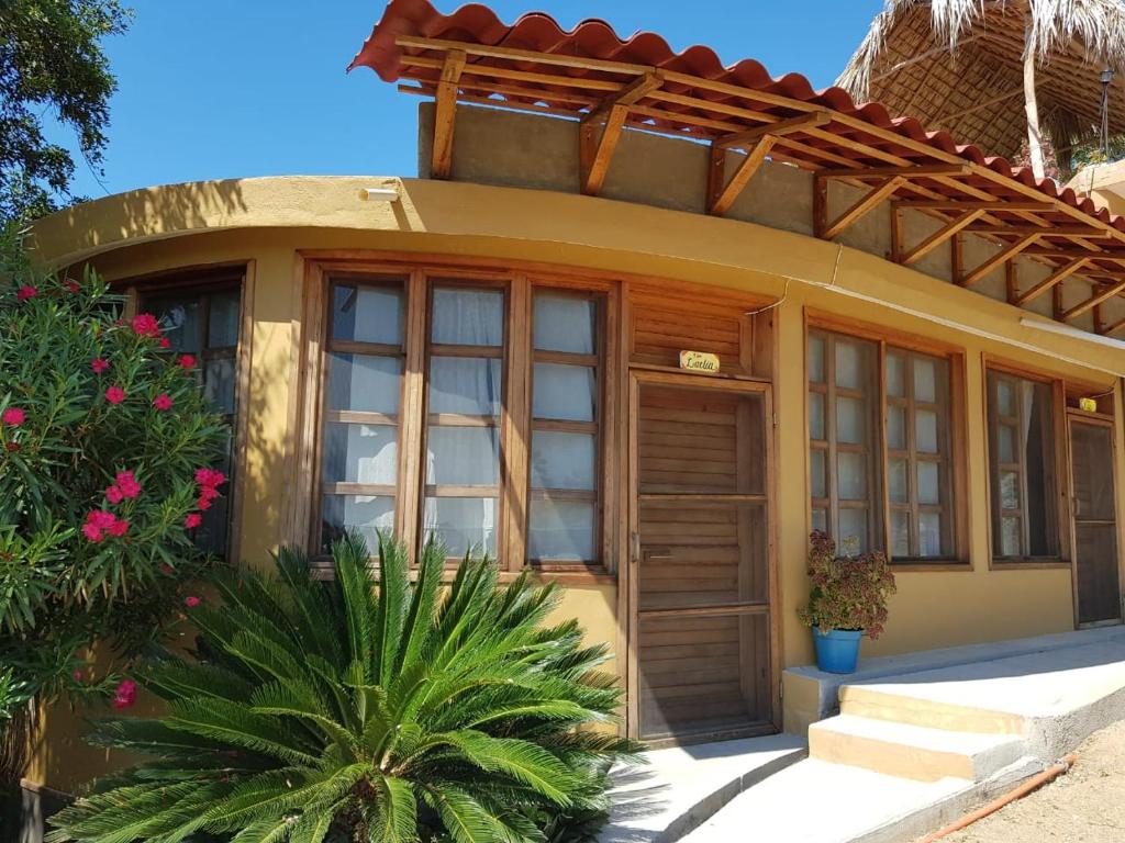 una pequeña casa con una puerta y algunas plantas en El Eden Bungalows, en Mazunte