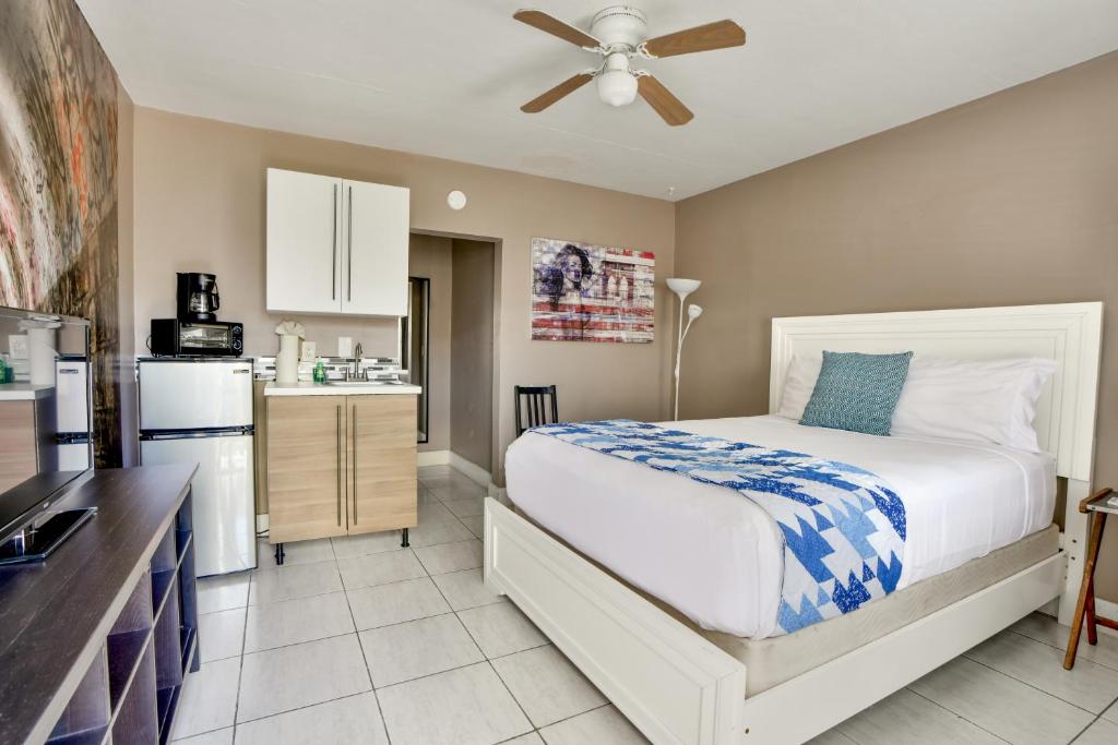 a bedroom with a large bed and a kitchen at Krymwood Flats Wynwood - By RocketStay in Miami