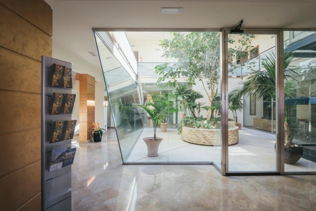 a large glass door in a building with potted plants at Hotel Costa Azul in Balestrate