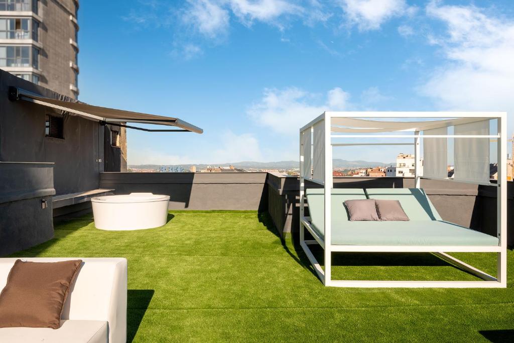 a balcony with a bed on the grass at Suite 1907 Oviedo in Oviedo