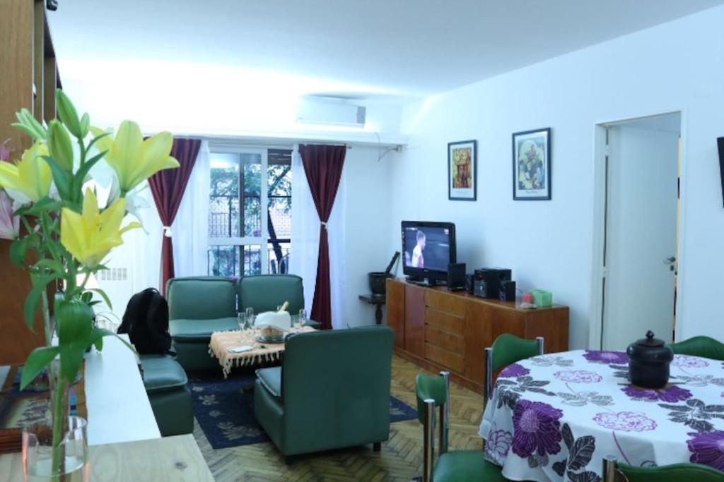 sala de estar con mesa, sillas y TV en Confortable dpto ,100 m2, cochera en el edificio gratis , balcon grande a la calle, cerca MOVISTAR ARENA en Buenos Aires