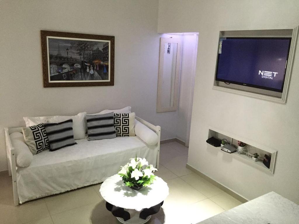 een woonkamer met een witte bank en een tv bij Confortavel Apartamento Copacabana in Rio de Janeiro