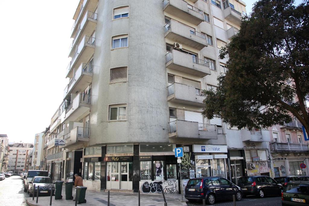 un edificio alto con coches estacionados frente a él en Lisbon Suite Home, en Lisboa