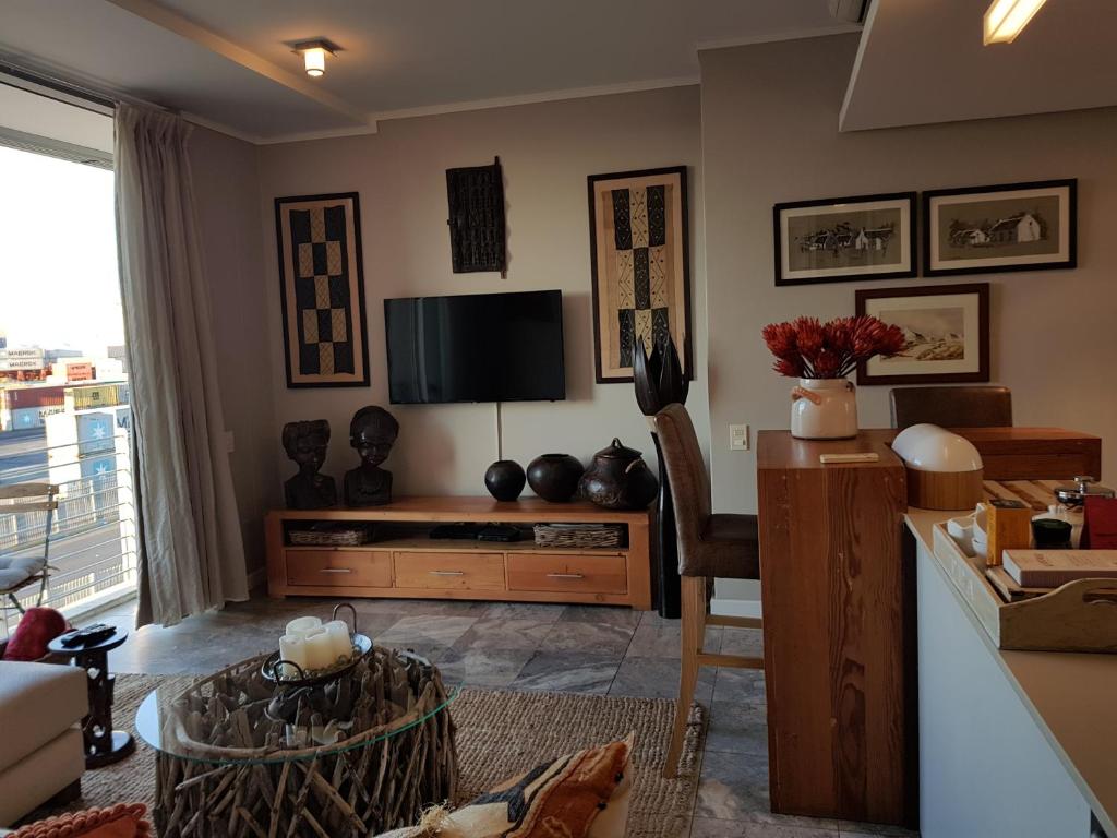 sala de estar con TV y mesa en Harbour Bridge Suite 220, en Ciudad del Cabo