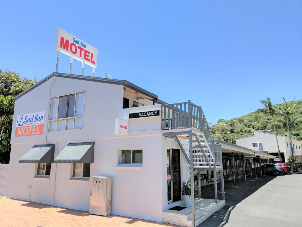 ein weißes Gebäude mit einem Schild darüber in der Unterkunft Sail Inn Motel in Yeppoon