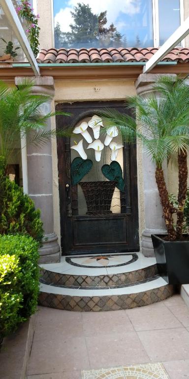 una entrada a una casa con una puerta con una planta en Casa Culhuac, en Ciudad de México