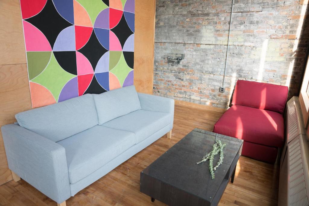 uma sala de estar com um sofá branco e uma cadeira vermelha em Hostel du Nord em Duluth