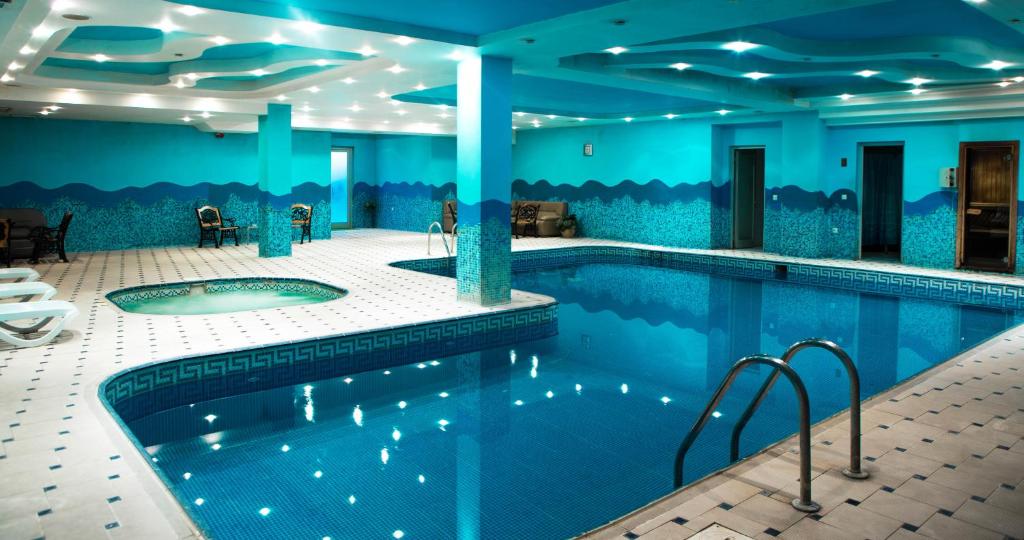 a pool in a hotel with blue walls at ABU ARENA HALL Hotel in Baku